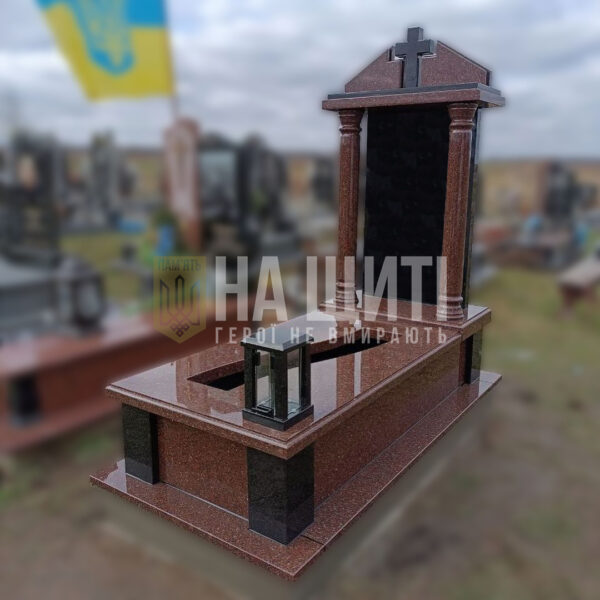 Монументальний пам'ятник воїну з червоного граніту з хрестом і колонами