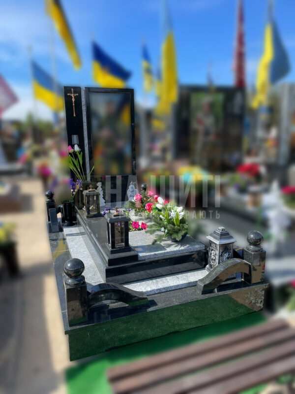 Пам'ятник для військових із чорного та сірого граніту з хрестом та лампадами.