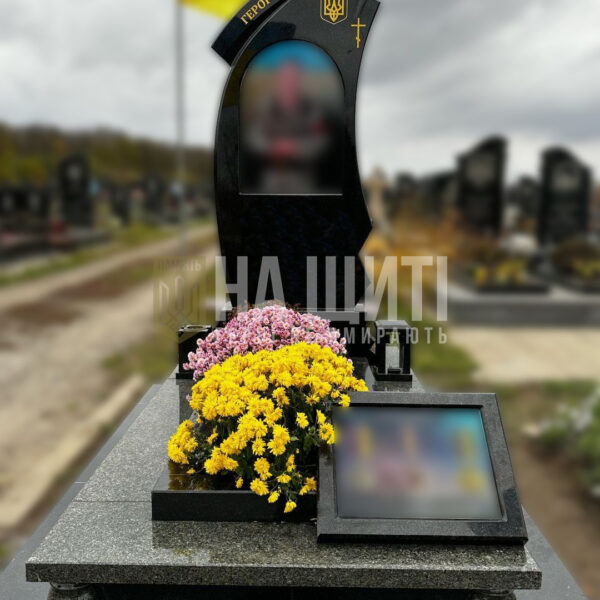 Асиметричний чорний гранітний пам'ятник з тризубом та написом "Герої не вмирають".