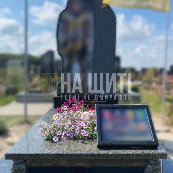 Пам'ятник воїну з чорного граніту з оригінальним дизайном і квітковим оформленням